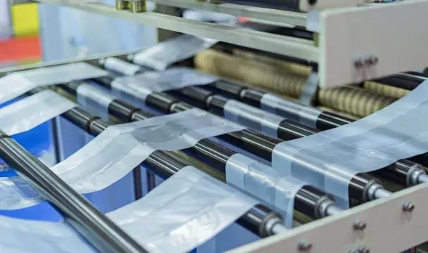Plastic film moving through a converting line at an advanced materials manufacturing plant