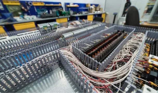 Wired control panel with terminal blocks and cable runs at an electrical manufacturing facility