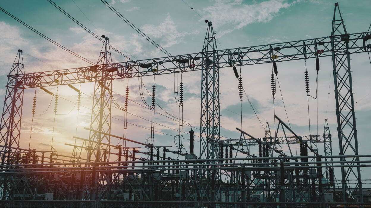High-voltage substation and transmission towers at sunset in the power and energy sector.