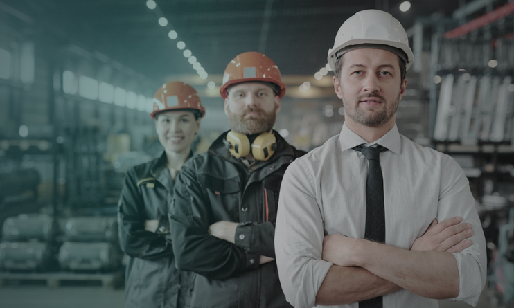 Three manufacturing leaders standing together on a plant floor